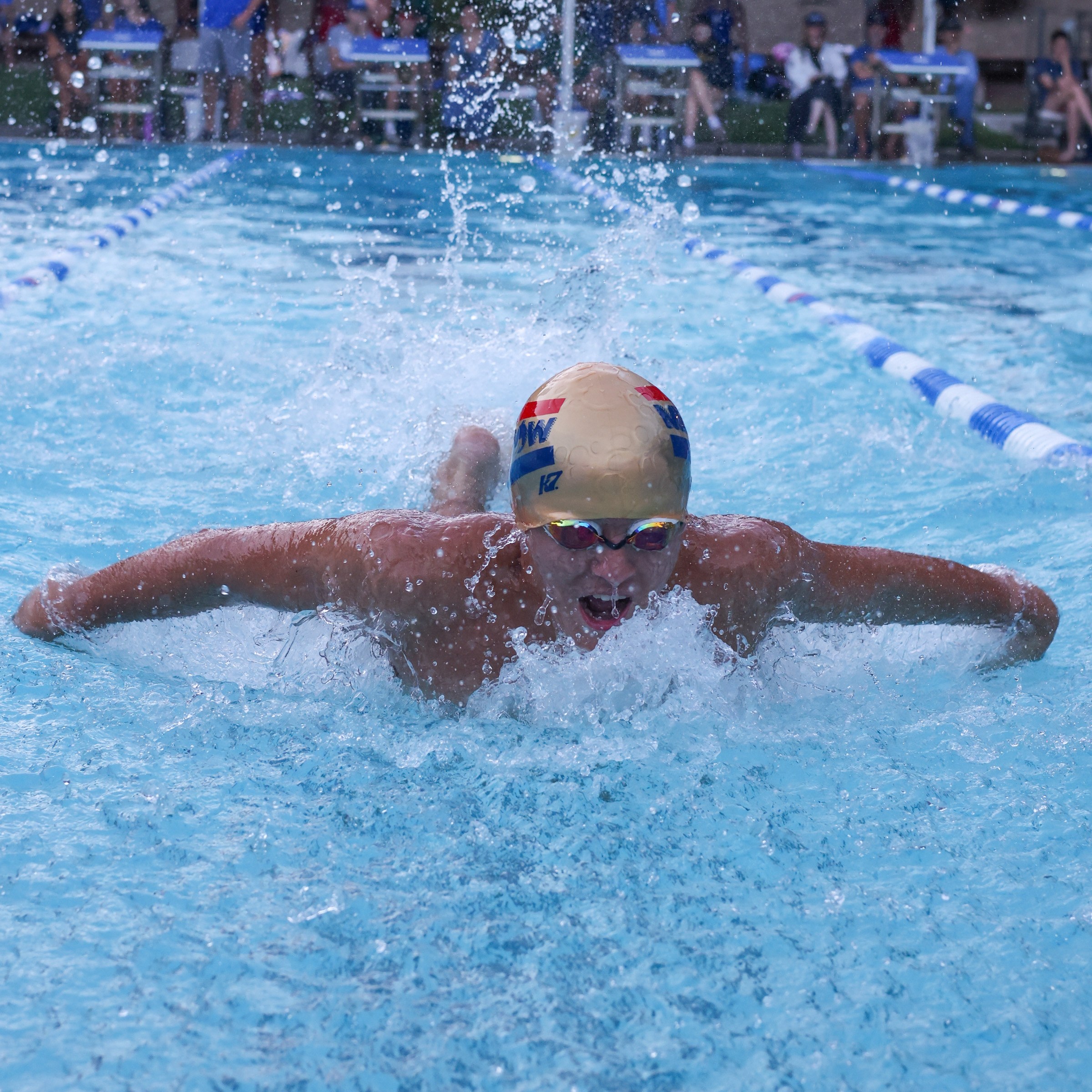 Butterfly swimmer breathing in a wall of whitewater